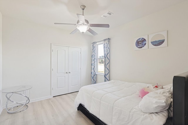 bedroom featuring light hardwood / wood-style floors, ceiling fan, and a closet