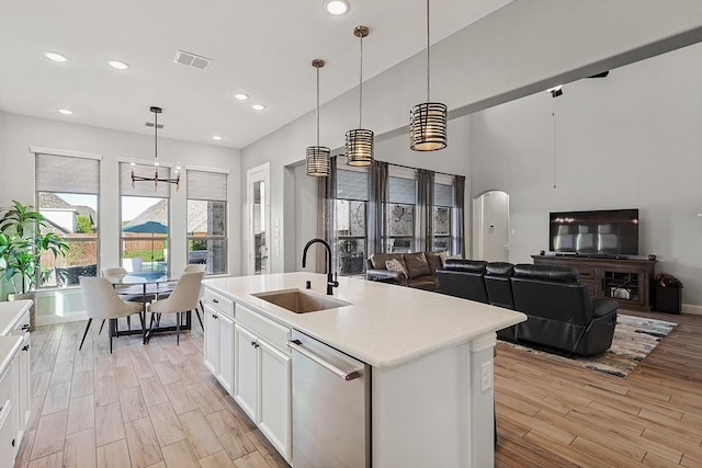 kitchen with dishwasher, sink, pendant lighting, a kitchen island with sink, and white cabinets