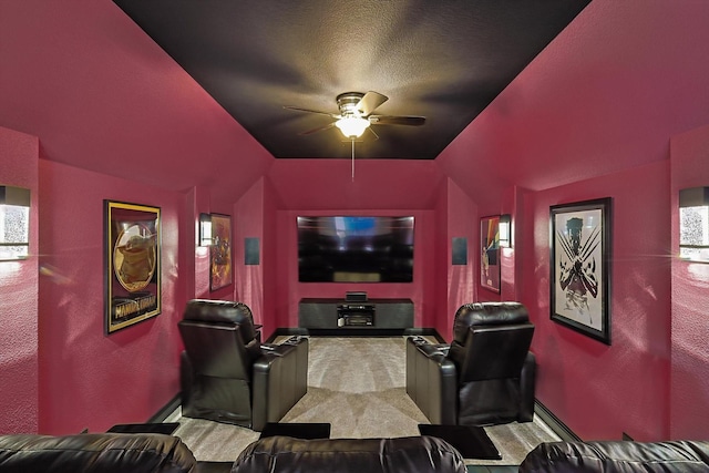 cinema room featuring lofted ceiling, ceiling fan, carpet floors, and a textured ceiling