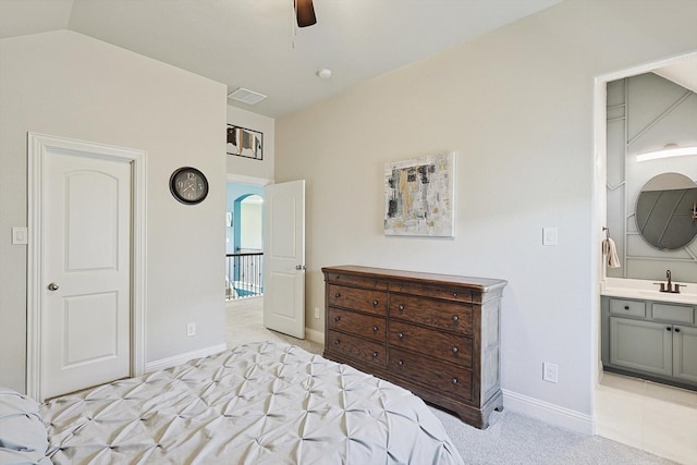 carpeted bedroom featuring vaulted ceiling, ensuite bath, ceiling fan, and sink