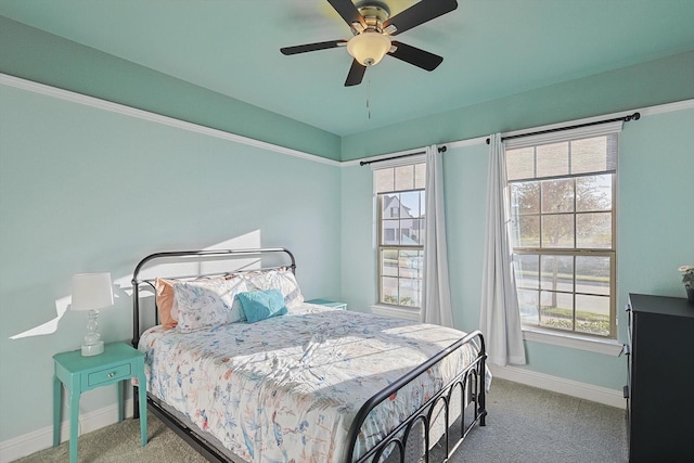 carpeted bedroom featuring ceiling fan and multiple windows