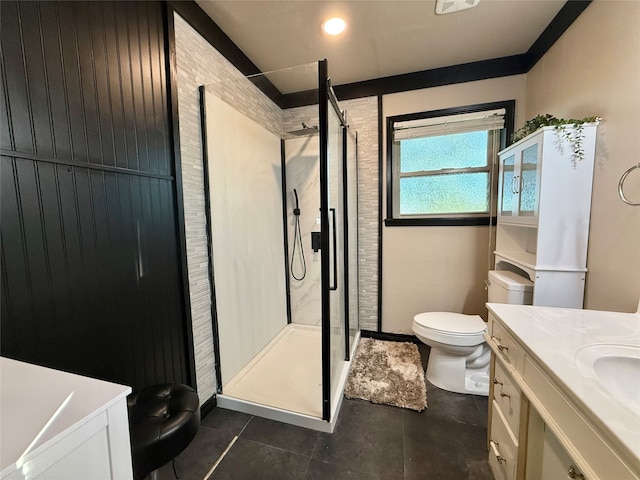 bathroom featuring tile patterned floors, vanity, toilet, and a shower with shower door