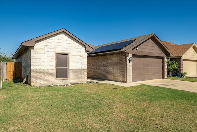 single story home featuring a front lawn, a garage, and solar panels