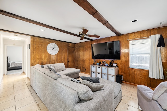 living room featuring ceiling fan, wooden walls, light tile patterned floors, and beam ceiling