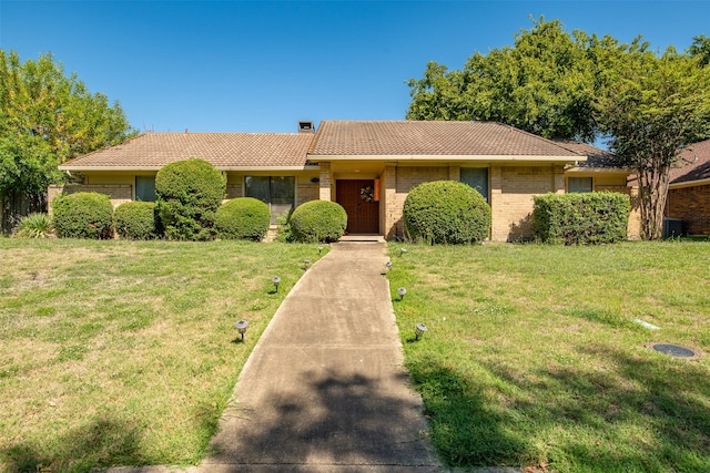 ranch-style house with central AC and a front lawn