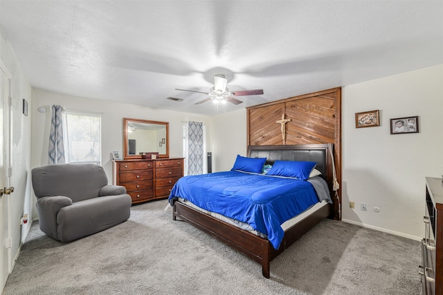 carpeted bedroom featuring a textured ceiling and ceiling fan