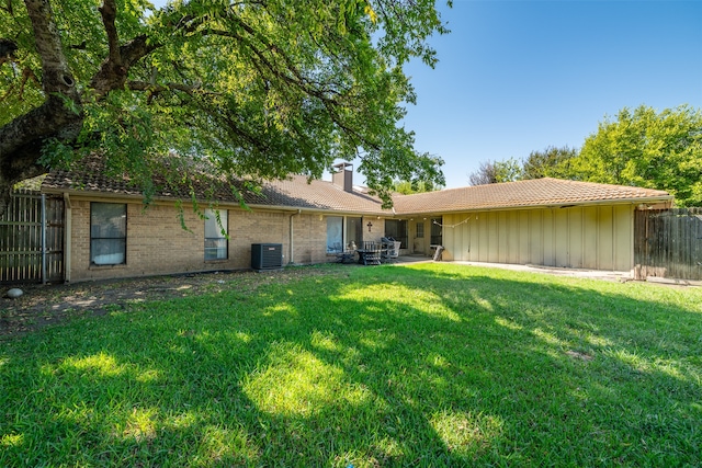 back of house featuring central air condition unit, a lawn, and a patio area