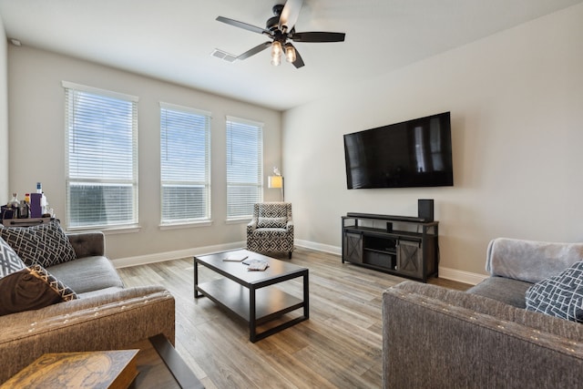 living room with light wood-type flooring and ceiling fan