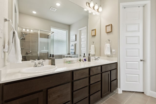 bathroom featuring vanity, a shower with door, and tile patterned flooring