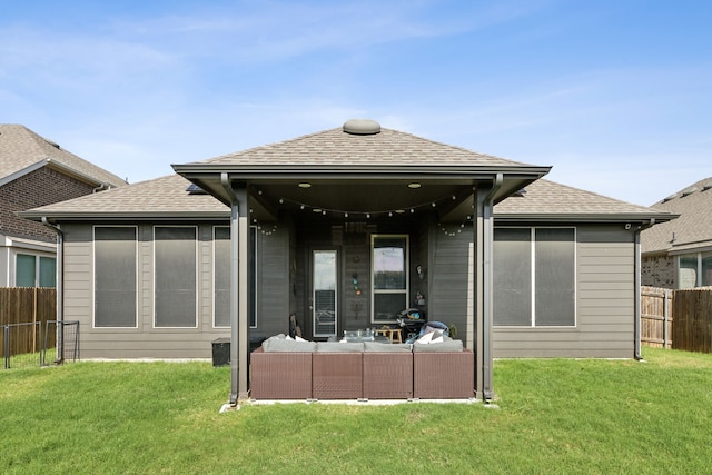 rear view of property with an outdoor living space and a yard