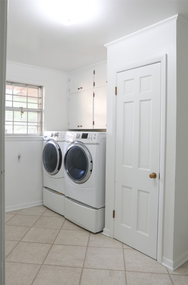 clothes washing area with cabinets, ornamental molding, light tile patterned floors, and independent washer and dryer