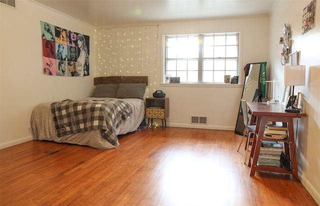 bedroom featuring hardwood / wood-style flooring and crown molding