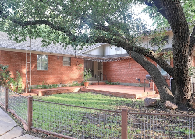 view of front of home with a patio area and a front yard