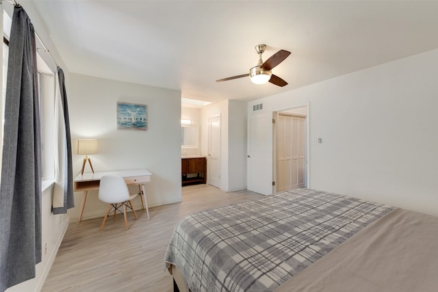 bedroom featuring ensuite bathroom, ceiling fan, a closet, and light hardwood / wood-style flooring