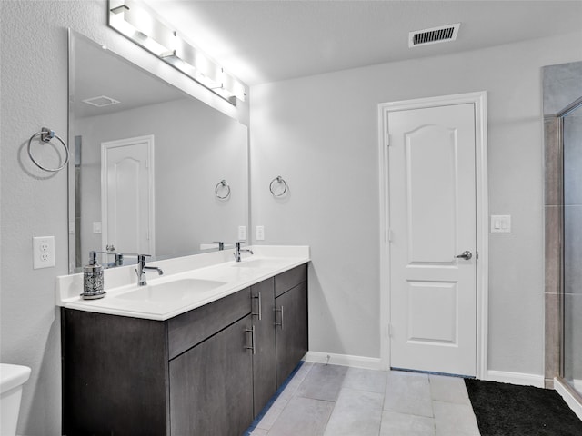 bathroom with tile patterned flooring, vanity, toilet, and a shower with shower door