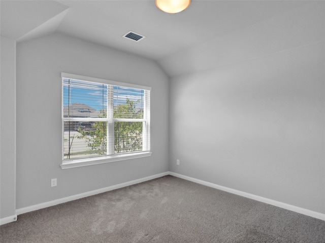 empty room featuring carpet and vaulted ceiling