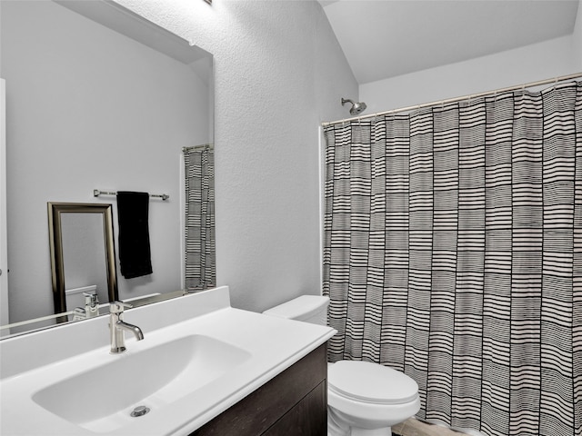 bathroom featuring curtained shower, vanity, toilet, and lofted ceiling