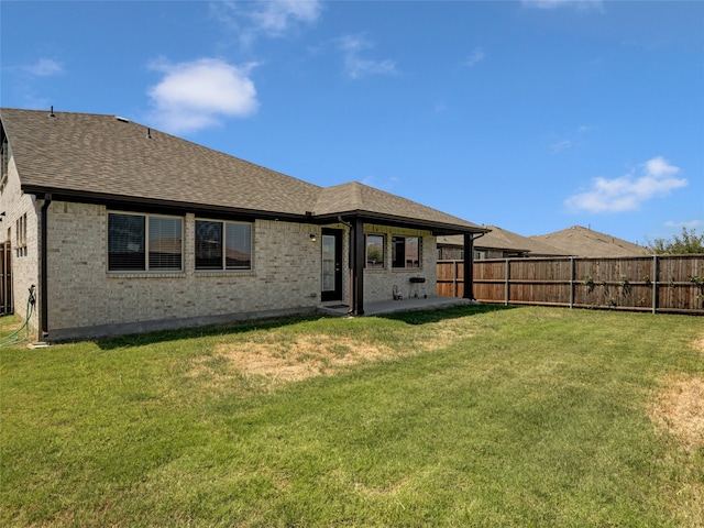 rear view of property featuring a yard and a patio area