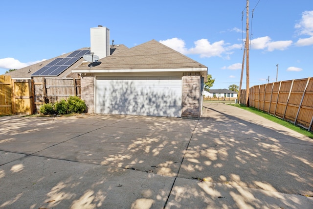 view of property exterior with solar panels and a garage