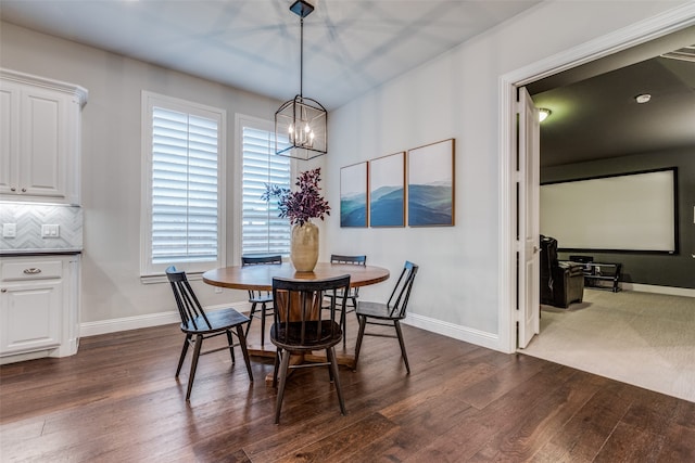 dining area with a chandelier, plenty of natural light, and dark wood-type flooring