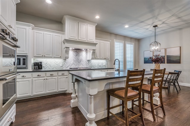 kitchen featuring white cabinets, decorative light fixtures, tasteful backsplash, and a chandelier