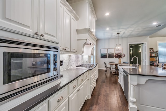 kitchen with white cabinets, appliances with stainless steel finishes, hanging light fixtures, and sink