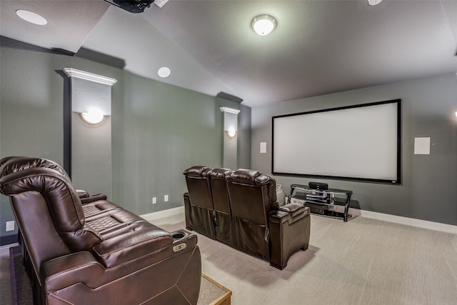 carpeted cinema room with vaulted ceiling