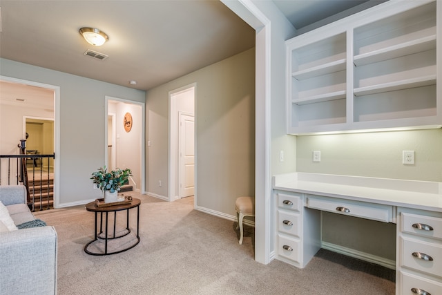 carpeted home office with built in desk