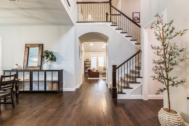 entrance foyer featuring a towering ceiling and dark hardwood / wood-style flooring