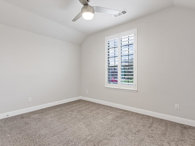 spare room featuring vaulted ceiling, carpet flooring, and ceiling fan