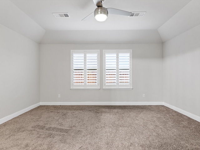 empty room with ceiling fan, lofted ceiling, and carpet