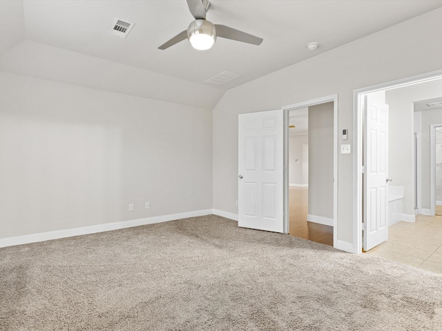 unfurnished bedroom with lofted ceiling, light carpet, ceiling fan, and ensuite bathroom