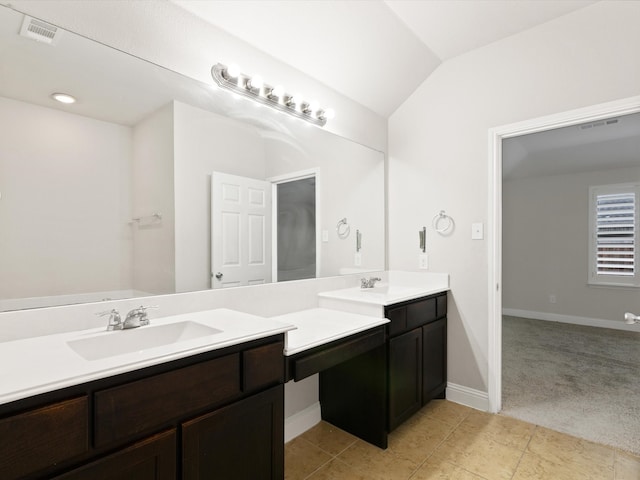 bathroom with vanity, tile patterned floors, and vaulted ceiling