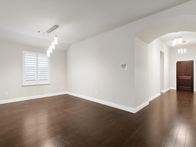 1200 Roadrunner Dr, Little Elm, TX 75068 - spare room featuring arched walkways, dark wood finished floors, baseboards, and a chandelier