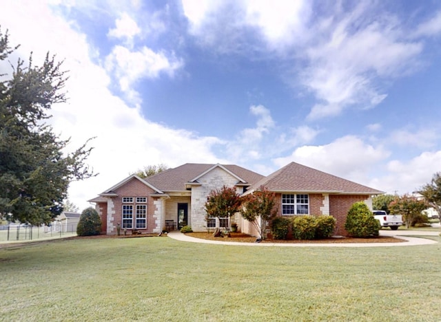 view of front of home with a front yard, brick siding, and fence