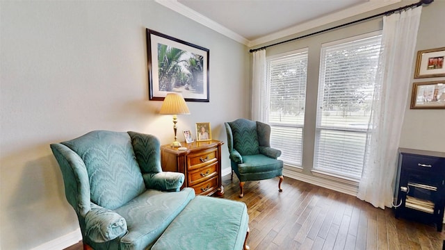 sitting room with crown molding, baseboards, and wood finished floors