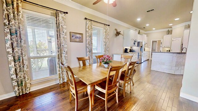 dining area with ornamental molding, dark wood finished floors, visible vents, and baseboards