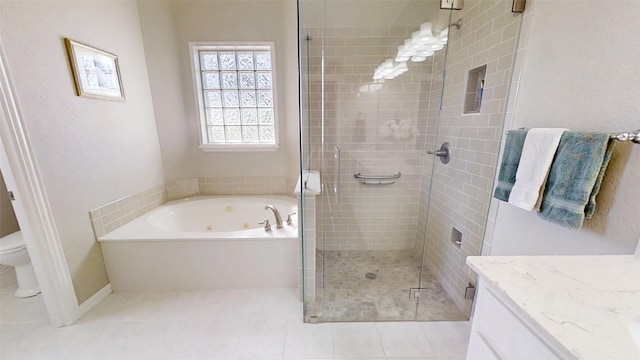 full bathroom featuring toilet, vanity, a shower stall, tile patterned floors, and a whirlpool tub