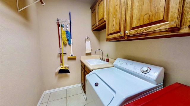 laundry room with light tile patterned floors, cabinet space, a sink, separate washer and dryer, and baseboards