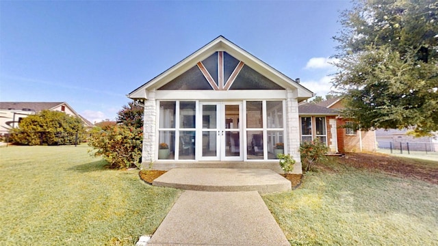 back of property featuring a sunroom and a yard