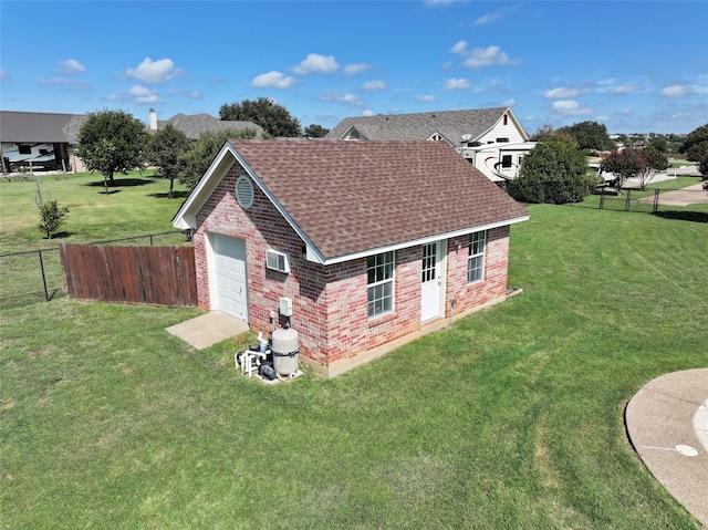 exterior space featuring driveway, roof with shingles, a yard, an outdoor structure, and brick siding