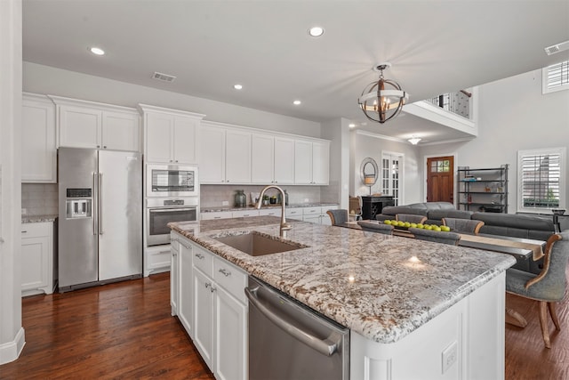 kitchen with a center island with sink, sink, white cabinetry, and appliances with stainless steel finishes