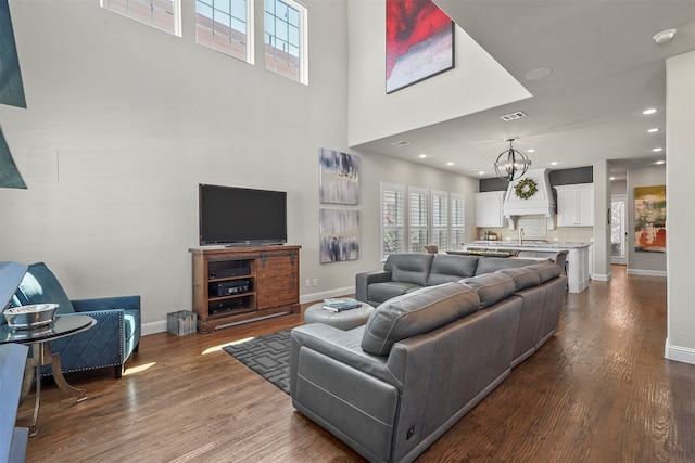 living room with dark hardwood / wood-style floors, a chandelier, and sink