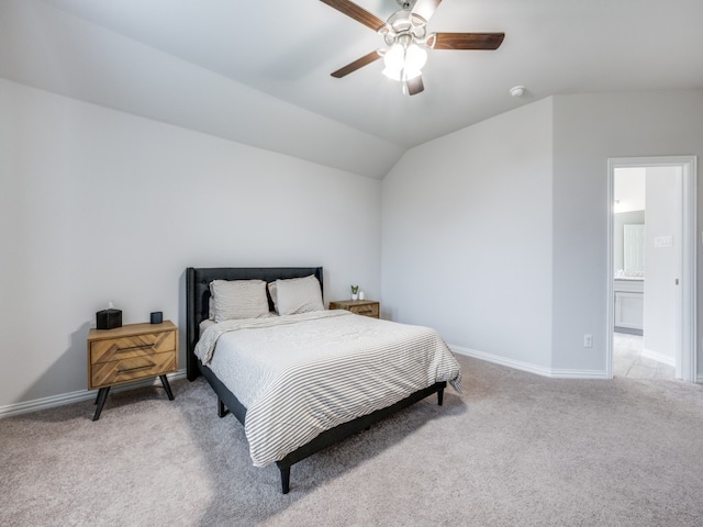 bedroom with ensuite bathroom, ceiling fan, light carpet, and vaulted ceiling