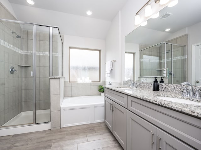 bathroom with vanity and shower with separate bathtub