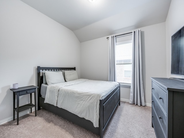 bedroom with light colored carpet and vaulted ceiling