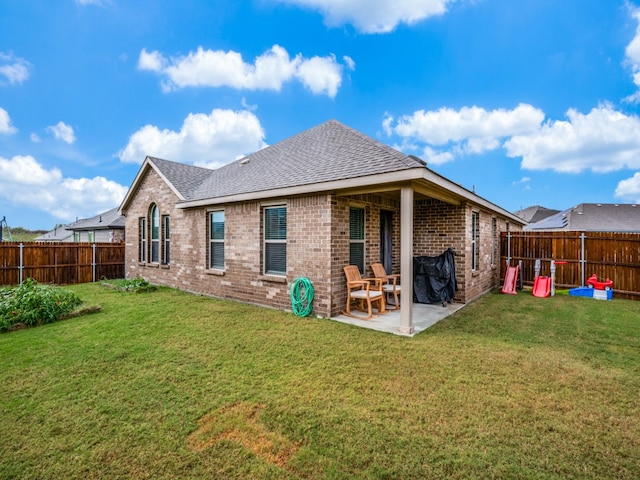 rear view of house featuring a lawn and a patio area