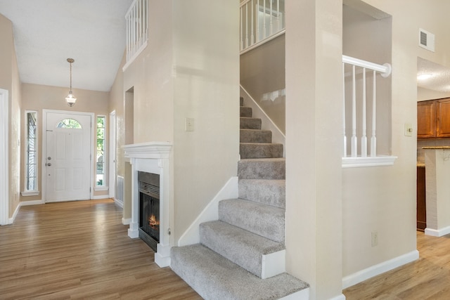 foyer featuring high vaulted ceiling and light hardwood / wood-style floors