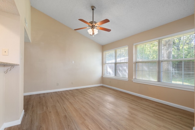 interior space with light wood-type flooring, vaulted ceiling, ceiling fan, and a healthy amount of sunlight