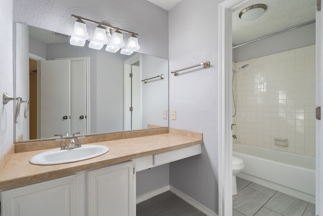 full bathroom featuring tile patterned floors, vanity, a textured ceiling, tiled shower / bath combo, and toilet